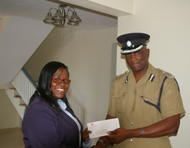Caribbean Cable Communications Branch Manager-Nevis, Mrs.Trecia Daniel handing over gift of complimentary cable to ACP Robert Liburd